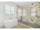 Bright bathroom showcasing a modern soaking tub and marble-tiled shower with natural light at 10380 Yellow Hammer Rd, Weeki Wachee, FL 34614