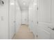 Bright hallway with hardwood floors, white walls, and multiple closet doors for ample storage at 10380 Yellow Hammer Rd, Weeki Wachee, FL 34614