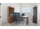 Well-lit home office with wooden desk, built-in shelves, and comfortable executive chair at 10380 Yellow Hammer Rd, Weeki Wachee, FL 34614