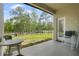Relaxing covered patio with seating and serene views of the fenced backyard and lush greenery at 10380 Yellow Hammer Rd, Weeki Wachee, FL 34614