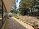 Landscaped backyard with lush lawn, brick border and mature shade trees at 10411 Ireland St, Spring Hill, FL 34608