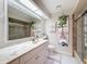 Well lit bathroom with marble countertop, decorative mirror and updated shower at 10411 Ireland St, Spring Hill, FL 34608