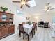 Open dining space with wood table and chairs, display cabinet, and seamless flow to home office area at 10411 Ireland St, Spring Hill, FL 34608