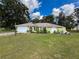 Single-story home with well-maintained lawn and landscaping, light green exterior, and attached garage at 10411 Ireland St, Spring Hill, FL 34608