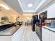 Modern kitchen with white cabinets, black countertops, stainless steel appliances and eat in bar at 10411 Ireland St, Spring Hill, FL 34608