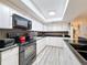 Efficient kitchen boasts ample counter space, black appliances, overhead lighting, and clean white cabinets at 10411 Ireland St, Spring Hill, FL 34608