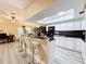 Open kitchen with white cabinets, black countertops, stainless steel appliances and eat in bar at 10411 Ireland St, Spring Hill, FL 34608
