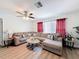 Spacious living room with a sectional couch, stylish coffee table, and large window with elegant curtains at 10411 Ireland St, Spring Hill, FL 34608