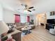 Bright living room with a comfortable sectional sofa, ceiling fan, and wood-look flooring at 10411 Ireland St, Spring Hill, FL 34608