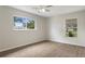 Bright bedroom with new floors, ceiling fan, and two windows at 10441 Mayflower Rd, Spring Hill, FL 34608