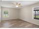 Bright bedroom features neutral walls, a ceiling fan, and sleek wood-look flooring at 10441 Mayflower Rd, Spring Hill, FL 34608