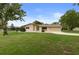 Charming single-story home featuring stone accents, a covered carport, and a well-maintained front lawn at 10441 Mayflower Rd, Spring Hill, FL 34608