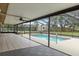 A screened-in pool area with a ceiling fan and an outdoor seating area at 10441 Mayflower Rd, Spring Hill, FL 34608