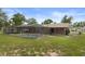 Backyard view of a screened pool with an attached patio, and lush green grass in a beautiful fenced-in yard at 10441 Mayflower Rd, Spring Hill, FL 34608