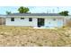 Exterior of home with large backyard, sliding glass doors, and a door at 11034 Harding Dr, Port Richey, FL 34668