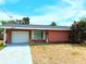 Charming single-story red brick home featuring an attached garage and a well-maintained lawn at 11034 Harding Dr, Port Richey, FL 34668