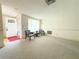 Bright living room featuring large window, neutral carpet, and cozy seating arrangement at 11034 Harding Dr, Port Richey, FL 34668