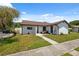 Charming townhome featuring a well-kept lawn, decorative plants, convenient parking, and a welcoming entryway at 11402 Shallowbrook Pl, Tampa, FL 33624