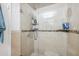 Tiled shower with glass door and convenient built-in shelving at 11402 Shallowbrook Pl, Tampa, FL 33624