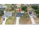 Aerial view of a single-Gathering home with a well-maintained lawn, long driveway and neighboring houses at 11494 Villa Rd, Spring Hill, FL 34609
