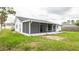 Fenced backyard view with grass, patio, and a screened in porch at 11494 Villa Rd, Spring Hill, FL 34609
