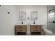 Bathroom with double vanity, dual mirrors, and tiled shower at 11494 Villa Rd, Spring Hill, FL 34609
