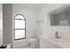 Bright bathroom with an arched window, modern vanity, and coordinating fixtures at 11494 Villa Rd, Spring Hill, FL 34609