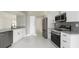 Renovated kitchen with stainless steel appliances, granite countertops, white cabinets, and tile flooring at 11494 Villa Rd, Spring Hill, FL 34609