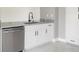 Close-up of kitchen featuring stainless steel dishwasher, granite countertops, white cabinets, and modern faucet at 11494 Villa Rd, Spring Hill, FL 34609