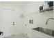 Laundry room with white walls, utility sink, and storage racks at 11494 Villa Rd, Spring Hill, FL 34609