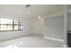 The light-filled living room features a window, stylish gray accent wall and sleek marble flooring at 11494 Villa Rd, Spring Hill, FL 34609