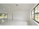 Bright living room with white walls, marble floors, recessed lighting, and large windows offering ample natural light at 11494 Villa Rd, Spring Hill, FL 34609