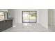 Open living space featuring sleek marble floors, modern sliding glass doors to a lanai, and a breakfast bar area at 11494 Villa Rd, Spring Hill, FL 34609