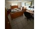 Bedroom with a wooden frame bed, tiled floors, and a small work desk at 11726 Oceanside Dr, Port Richey, FL 34668