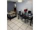 Dining area featuring a modern glass-top table, black chairs, and decorative lighting at 11726 Oceanside Dr, Port Richey, FL 34668