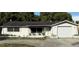 Cozy one story home featuring a front yard, an attached garage, and a front porch with lawn chairs at 11726 Oceanside Dr, Port Richey, FL 34668