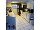 Functional kitchen with white cabinets, black appliances, and tile flooring at 11726 Oceanside Dr, Port Richey, FL 34668