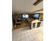 Open concept living room flowing into the kitchen with white tiled floors throughout at 11726 Oceanside Dr, Port Richey, FL 34668