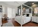Bedroom features a white four poster bed, dark green accent wall, and sliding glass doors at 12403 Moneta Rd, Weeki Wachee, FL 34614