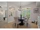 Dining area with a modern glass table, four chairs, and a large window offering natural light and views at 12403 Moneta Rd, Weeki Wachee, FL 34614