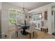 Elegant dining area features a round table with seating, chandelier, and a window overlooking the backyard at 12403 Moneta Rd, Weeki Wachee, FL 34614