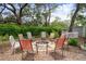 Outdoor firepit surrounded by chairs, lush greenery, and trees, ideal for relaxing and entertaining guests at 12403 Moneta Rd, Weeki Wachee, FL 34614