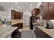 Spacious kitchen featuring dark wood cabinets, stainless steel appliances, and granite countertops at 12403 Moneta Rd, Weeki Wachee, FL 34614