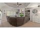 Bright living room featuring a large leather sectional, built-in shelving, and tile flooring throughout the space at 12403 Moneta Rd, Weeki Wachee, FL 34614
