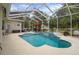 Relaxing screened-in pool featuring a waterfall, spa, outdoor seating, and a tropical backyard at 12403 Moneta Rd, Weeki Wachee, FL 34614