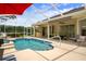 Inviting screened-in pool area with a bar, dining area, and lush landscaping creating a perfect outdoor oasis at 12403 Moneta Rd, Weeki Wachee, FL 34614