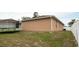 View of the back side of a tan house featuring a fenced yard, a trampoline, and lawn at 12458 Fish Cove Dr, Spring Hill, FL 34609