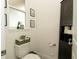Cozy half bathroom with storage cabinet, decorative shelves, and a frosted window for soft, natural light at 12458 Fish Cove Dr, Spring Hill, FL 34609