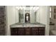 A well-lit bathroom with double vanities and granite countertops at 12458 Fish Cove Dr, Spring Hill, FL 34609
