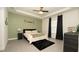Bright bedroom with a tray ceiling, stylish black accents, and neutral walls complemented by modern gray flooring at 12458 Fish Cove Dr, Spring Hill, FL 34609